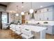Modern kitchen boasts white cabinets, stainless steel appliances, a large island with seating and pendant lighting at 2739 Ravencliffe Ter, Oviedo, FL 32765
