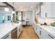 Bright eat-in kitchen with stainless steel appliances, white cabinets, hardwood floors, and modern lighting at 2739 Ravencliffe Ter, Oviedo, FL 32765