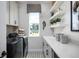 Well-organized laundry room with modern appliances, ample counter space, and open shelving for storage at 2739 Ravencliffe Ter, Oviedo, FL 32765