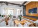 Open-concept living room with hardwood floors, modern furnishings, a coffered ceiling, and a wall-mounted TV at 2739 Ravencliffe Ter, Oviedo, FL 32765