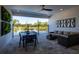 Covered patio with outdoor seating, a black dining table, and a view of the pool and backyard at 2739 Ravencliffe Ter, Oviedo, FL 32765
