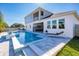 Inviting backyard pool with a sun shelf, paver patio, and lush landscaping, perfect for outdoor relaxation and entertaining at 2739 Ravencliffe Ter, Oviedo, FL 32765