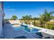 A backyard pool offers a refreshing escape with its sun shelf, complemented by palm trees at 2739 Ravencliffe Ter, Oviedo, FL 32765
