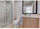 Well-lit bathroom featuring a glass shower, toilet, vanity with mirror, and neutral tile flooring at 3019 White Orchid Rd, Kissimmee, FL 34747