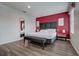 Bedroom featuring an accent wall, bed, bench, and wood-look flooring at 3019 White Orchid Rd, Kissimmee, FL 34747