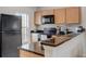 Cozy kitchen featuring modern appliances, sleek countertops, and wood cabinetry for a welcoming atmosphere at 3019 White Orchid Rd, Kissimmee, FL 34747