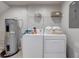 Functional laundry area with washer, dryer, shelving, and water heater at 3019 White Orchid Rd, Kissimmee, FL 34747