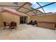 Enclosed patio with a hot tub, lounge chairs, table, and shade umbrella at 3019 White Orchid Rd, Kissimmee, FL 34747