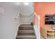 Carpeted stairway with white banister and a pop of color on the accent wall at 3019 White Orchid Rd, Kissimmee, FL 34747