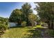 Green backyard with mature trees and a white fence, creating a serene outdoor retreat at 3121 Thistlehill Drive, Winter Park, FL 32792