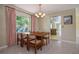 Dining room with a wood table set, soft, natural lighting and an ornate chandelier above at 3121 Thistlehill Drive, Winter Park, FL 32792