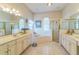 Bright bathroom featuring a soaking tub, glass-enclosed shower, and double vanity sinks with tile flooring at 34239 Woodridge Ln, Eustis, FL 32736