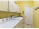 Laundry room featuring washer and dryer, storage cabinets, and door to backyard at 34239 Woodridge Ln, Eustis, FL 32736