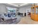 Comfortable living room with plush seating, large windows, and an adjacent bedroom with hardwood floors at 34239 Woodridge Ln, Eustis, FL 32736