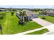 Aerial view of a well-kept single-story home with 3-car garage and inviting front porch with a green lawn at 3630 Trimaran Dr, Orlando, FL 32820