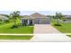 Well-maintained one-story home featuring a 3-car garage, cozy front porch and lush green lawn with palm trees at 3630 Trimaran Dr, Orlando, FL 32820