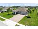 Aerial view showcases a gray single-story home, 3-car garage, a charming porch and a well-maintained lawn at 3630 Trimaran Dr, Orlando, FL 32820