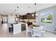 Kitchen with a quartz island, seating, pendant lights, dark cabinets, dining area, and stainless steel appliances at 3630 Trimaran Dr, Orlando, FL 32820