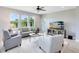 Bright living room with light grey walls, a ceiling fan, three large windows, and plank flooring at 3630 Trimaran Dr, Orlando, FL 32820
