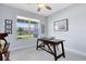 Bright home office with a large window, ceiling fan, and simple wooden desk and chair at 3630 Trimaran Dr, Orlando, FL 32820