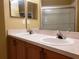 Bathroom featuring double sink vanity, large mirror, and walk-in shower with clear glass doors at 3658 Oakdale Cir # 100, Oviedo, FL 32765