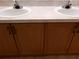 Bathroom vanity featuring double sinks, granite countertop, and dark wood cabinets for ample storage space at 3658 Oakdale Cir # 100, Oviedo, FL 32765