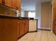 Kitchen featuring white dishwasher, wood cabinets, granite countertops with a view into the living area at 3658 Oakdale Cir # 100, Oviedo, FL 32765