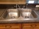 Close-up of a stainless steel, double-basin kitchen sink with chrome faucet and sprayer at 3658 Oakdale Cir # 100, Oviedo, FL 32765