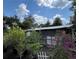 Backyard with a covered porch surrounded by lush greenery and assorted potted plants at 40431 Country Rd, Eustis, FL 32736