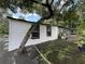Backyard with a tree growing against the home's exterior and a variety of potted plants at 40431 Country Rd, Eustis, FL 32736
