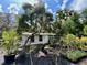 Scenic backyard view showcasing a cozy home surrounded by a diverse array of potted plants at 40431 Country Rd, Eustis, FL 32736