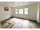 Bright bedroom with three windows and wood-look flooring, providing a calm, simple space at 40431 Country Rd, Eustis, FL 32736