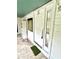 Exterior entrance with a white door and security camera, leading into a bright, enclosed porch at 40431 Country Rd, Eustis, FL 32736