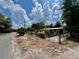 Quaint home with a gated front yard, showcasing beautiful landscaping and a serene setting, with a bright, cloudy sky at 40431 Country Rd, Eustis, FL 32736
