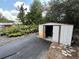 Photo features an open metal storage shed surrounded by various potted plants and greenery at 40431 Country Rd, Eustis, FL 32736