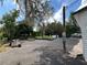 Property featuring an outdoor storage area with trees, plants in pots and a weathered utility pole at 40431 Country Rd, Eustis, FL 32736