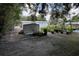 Property featuring an outdoor area with trees, plants in pots, greenery and a metal shed at 40431 Country Rd, Eustis, FL 32736