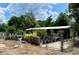 A charming home with a metal roof, surrounded by lush plants, and gated yard, creating a serene and private setting at 40431 Country Rd, Eustis, FL 32736