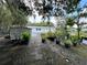 Property featuring an outdoor area with trees, plants in pots, greenery and a white metal shed at 40431 Country Rd, Eustis, FL 32736