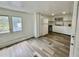 Well-lit kitchen with white cabinets, appliances, wood-look flooring, and a view of the backyard at 40431 Country Rd, Eustis, FL 32736