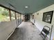 Long screened porch with concrete floors, ceiling fan, and view of the outdoor garden at 40431 Country Rd, Eustis, FL 32736