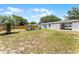 Spacious backyard featuring a fire pit area, privacy fence, and partial view of the home's exterior at 410 W Seminole Ave, Eustis, FL 32726
