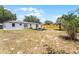Spacious backyard featuring a fire pit area, privacy fence, and partial view of the home's exterior at 410 W Seminole Ave, Eustis, FL 32726