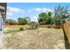 Large backyard with wooden fence and a charming fire pit seating area at 410 W Seminole Ave, Eustis, FL 32726