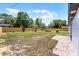 Spacious backyard featuring a wooden fence, lush grass, and a charming patio seating area at 410 W Seminole Ave, Eustis, FL 32726