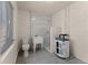 Bathroom with white-tiled shower, toilet, and simple sink, combined with a water heater at 410 W Seminole Ave, Eustis, FL 32726