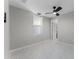 Neutral bedroom with great natural light, stylish ceiling fan, and modern tiled floors at 410 W Seminole Ave, Eustis, FL 32726