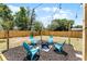 Backyard seating area featuring a modern fire pit, blue chairs, mulch, and string lights at 410 W Seminole Ave, Eustis, FL 32726