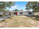 Charming one-story home with a covered carport, bright red door, and freshly painted white exterior at 410 W Seminole Ave, Eustis, FL 32726