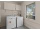 Well-lit laundry room with a washer, dryer, overhead cabinets and a window at 410 W Seminole Ave, Eustis, FL 32726
